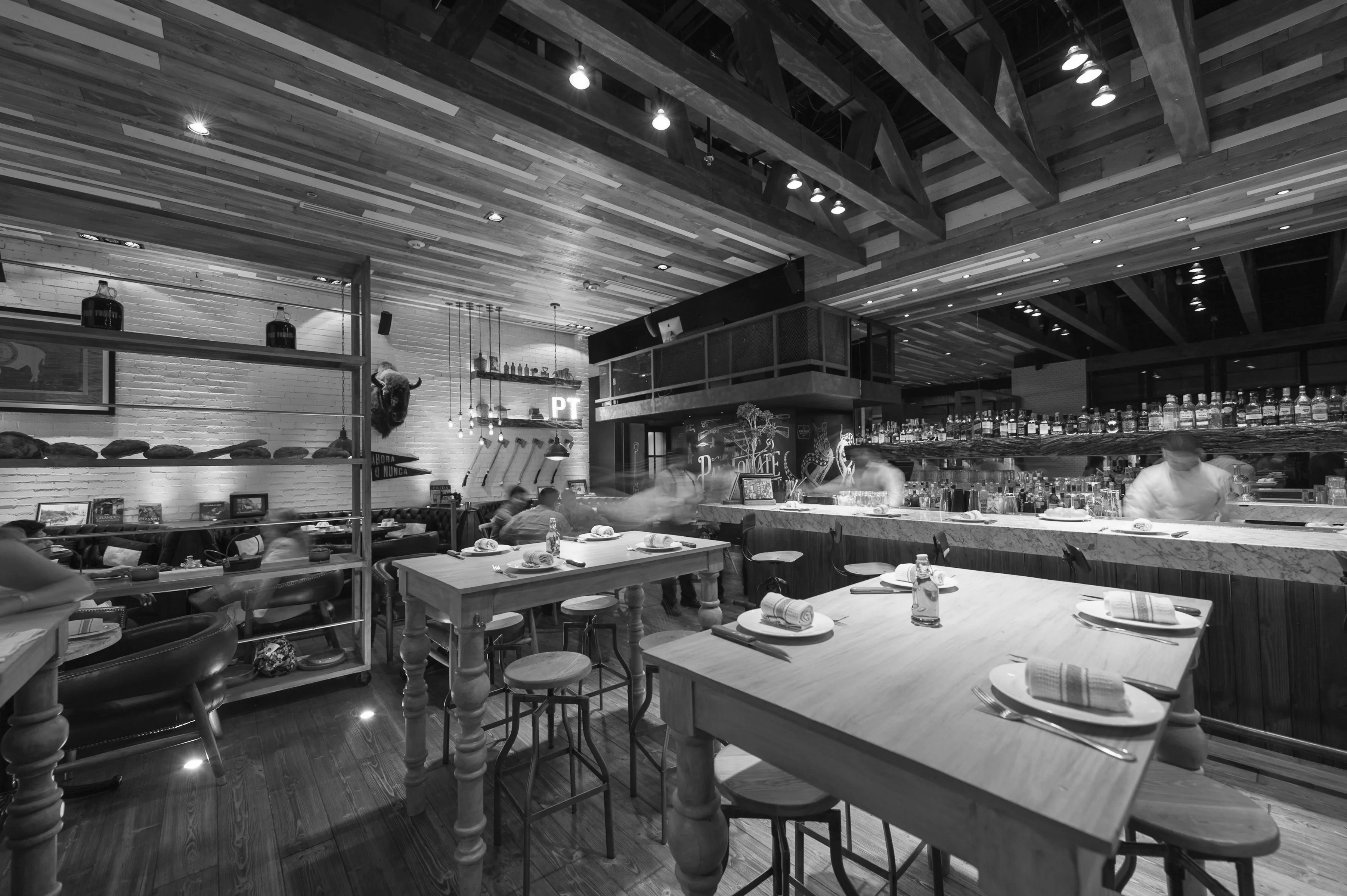 Interior de restaurante con estructura vista y cocina abierta